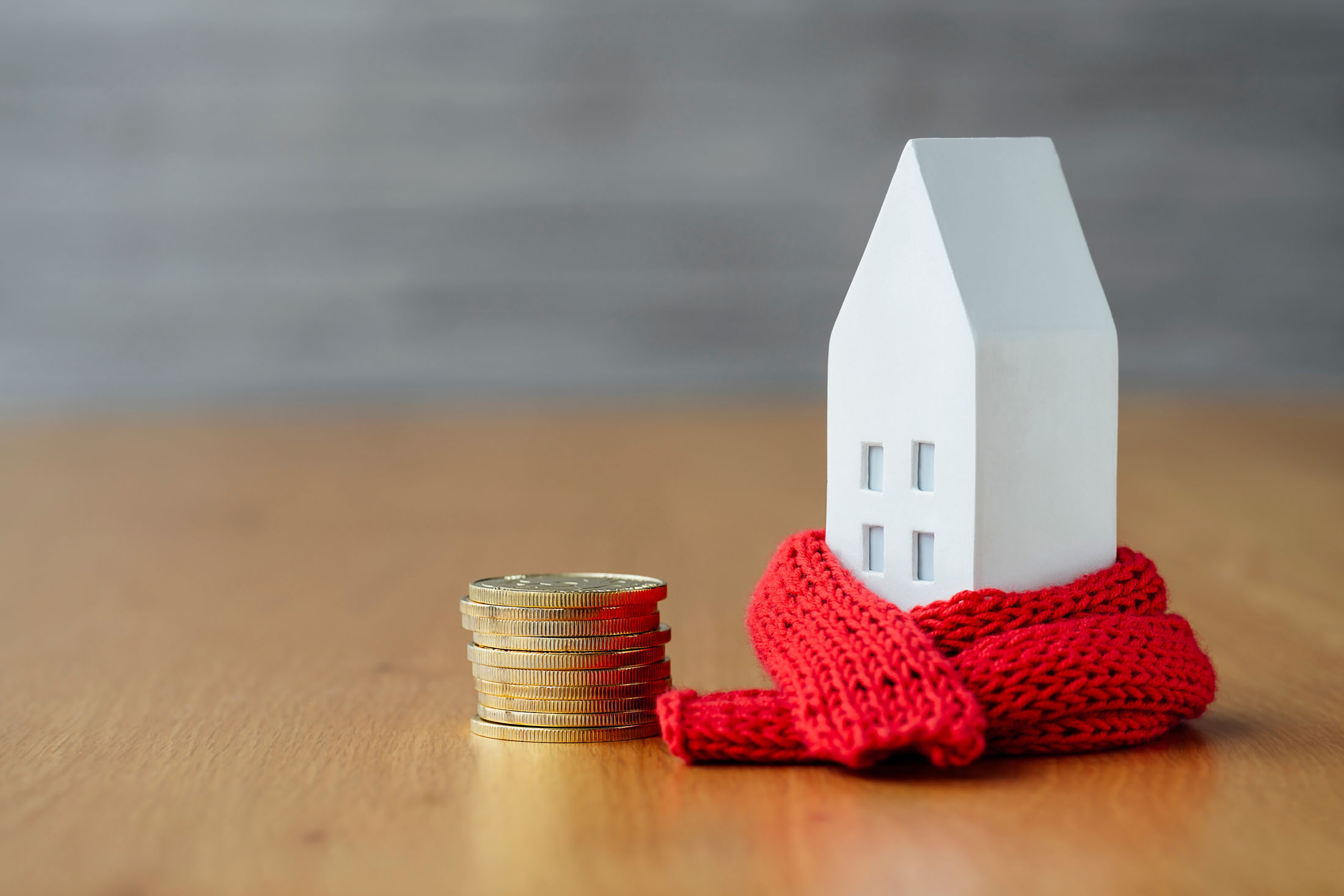 Miniature,House,In,A,Red,Scarf,With,Coins,On,Wooden miniature house with coins