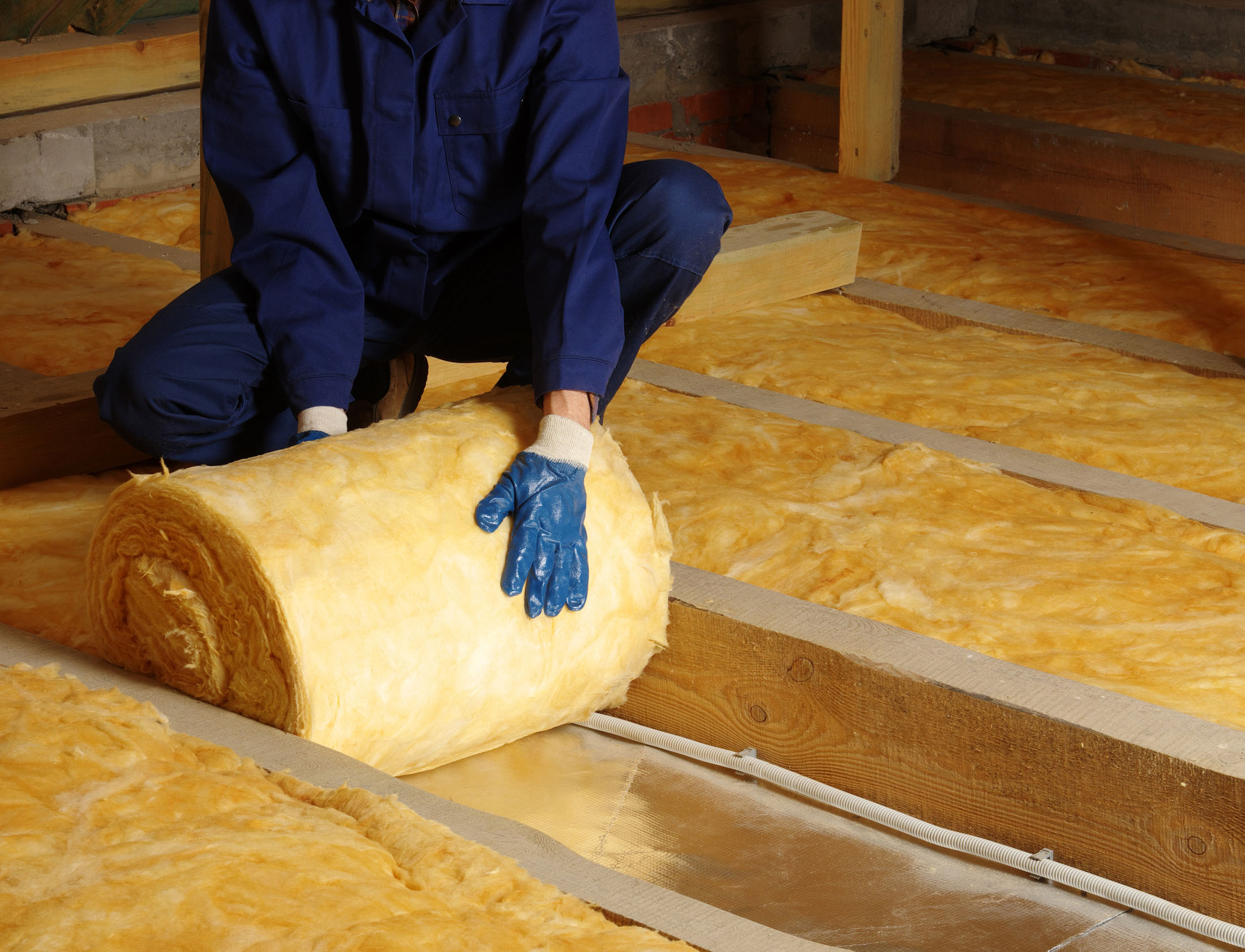 Construction,Worker,Thermally,Insulating,House,Attic,With,Glass,Wool thermal insulation in a house attic glass wool