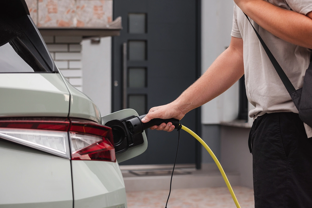 Man charging electric car with home charger