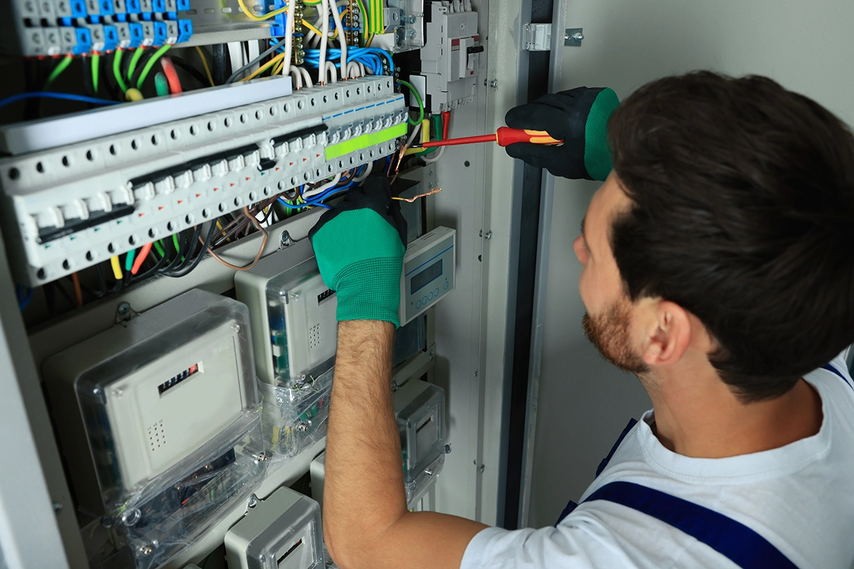 An electrician working on a fuse box